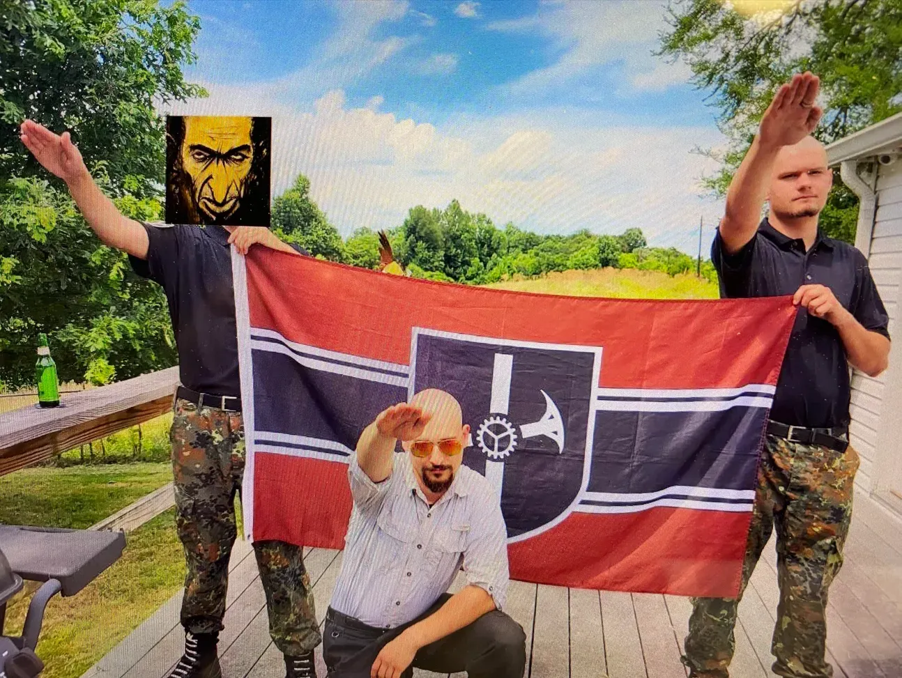 Automata members making a Sieg Heil salute with the group’s flag. Cuevas (left), Nary (center), and Crews (right) (2023).